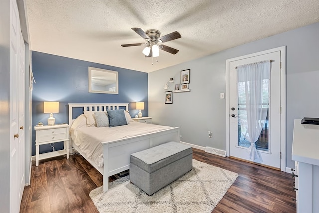 bedroom featuring a textured ceiling, ceiling fan, dark wood-type flooring, and access to outside