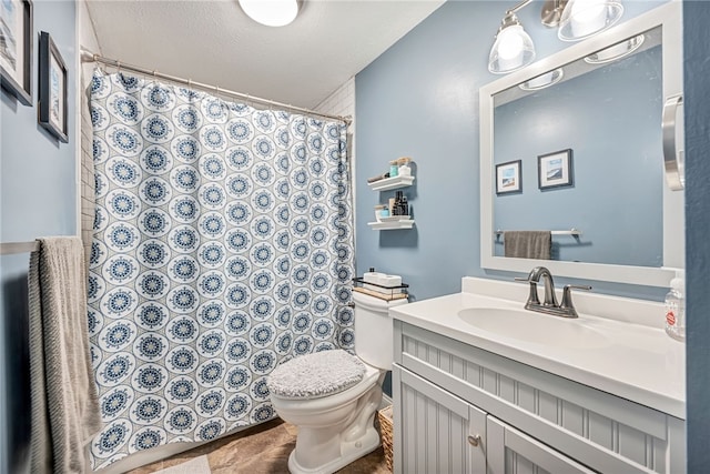 bathroom with vanity, a textured ceiling, and toilet