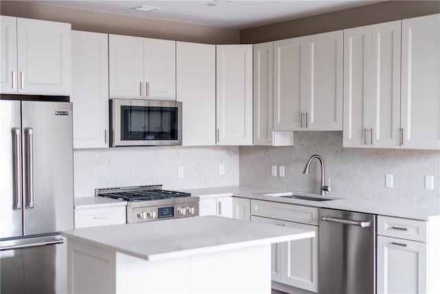 kitchen featuring a kitchen island, sink, white cabinetry, and stainless steel appliances