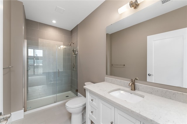 bathroom featuring tile patterned floors, vanity, a shower with shower door, and toilet