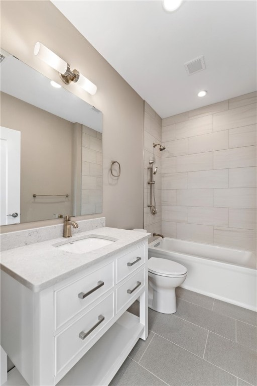 full bathroom featuring tile patterned flooring, vanity, toilet, and tiled shower / bath