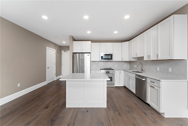 kitchen with a center island, high quality appliances, white cabinets, sink, and dark hardwood / wood-style floors