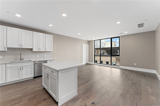 kitchen featuring dishwasher, hardwood / wood-style floors, white cabinets, and sink