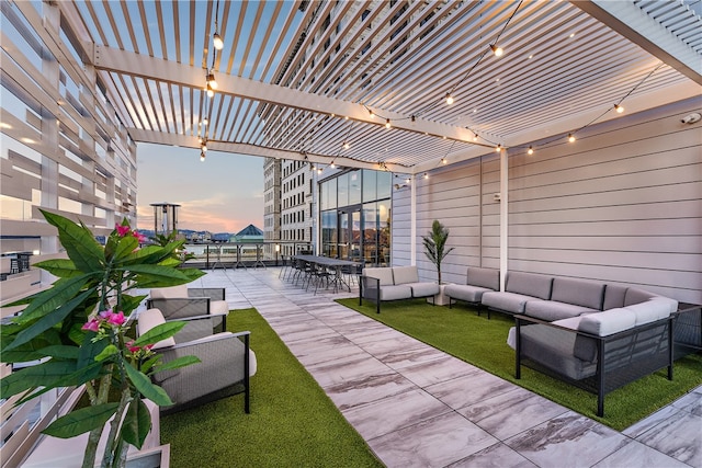 patio terrace at dusk featuring a pergola and an outdoor hangout area