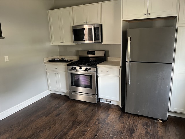 kitchen with white cabinetry, stainless steel appliances, and dark wood-type flooring