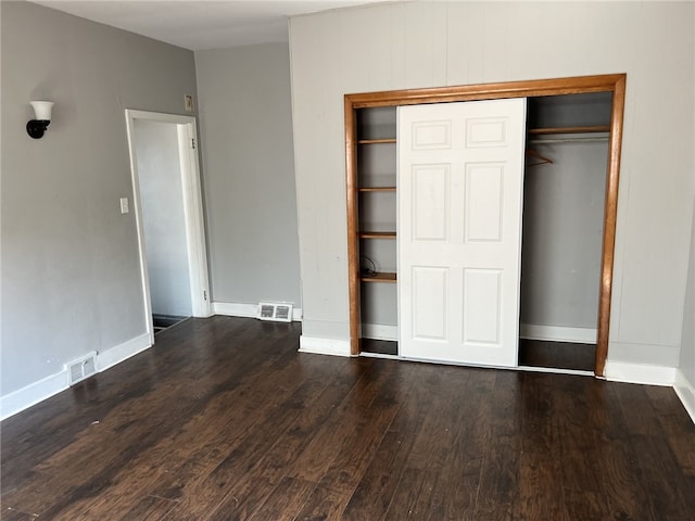 unfurnished bedroom featuring a closet and hardwood / wood-style floors