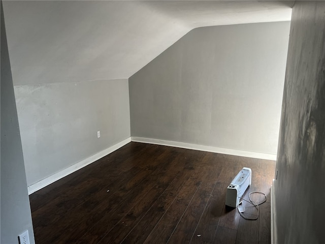 additional living space featuring dark wood-type flooring and lofted ceiling