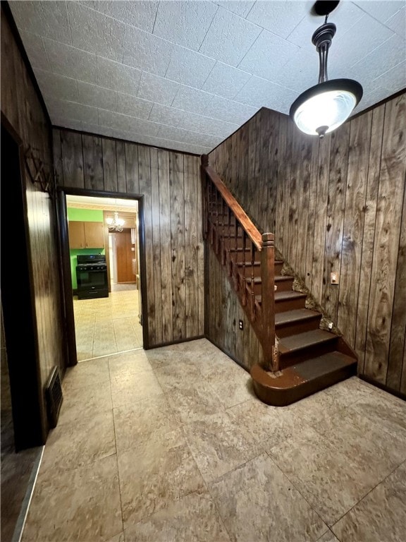 stairs featuring wood walls