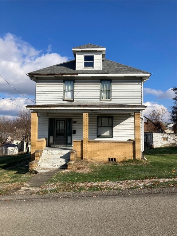 front facade with covered porch and a front lawn