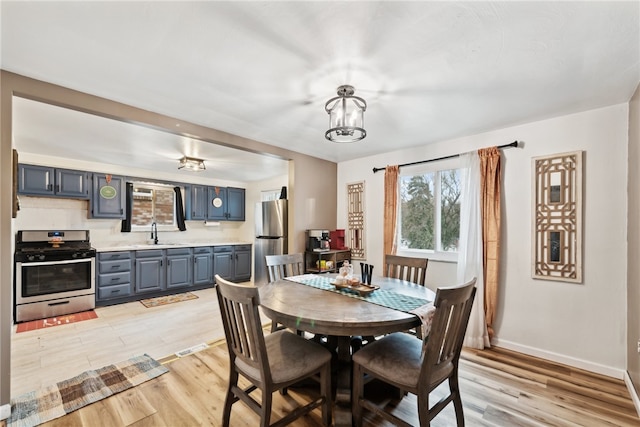 dining space featuring sink and light wood-type flooring