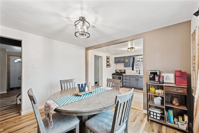 dining room featuring light wood-type flooring, ceiling fan, and sink