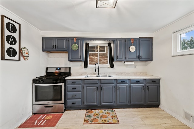 kitchen with gray cabinetry, stainless steel range, and sink