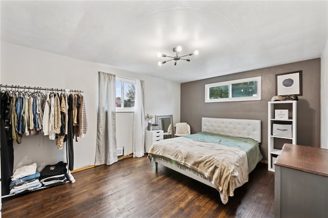 bedroom with dark wood-type flooring and a notable chandelier