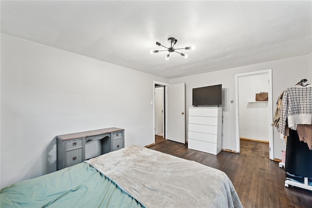 bedroom with dark hardwood / wood-style floors and an inviting chandelier