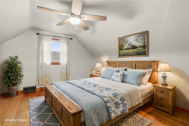 bedroom with ceiling fan, wood-type flooring, and lofted ceiling