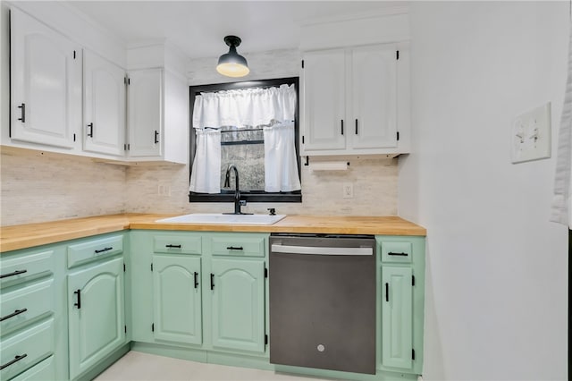 kitchen with wood counters, tasteful backsplash, stainless steel dishwasher, sink, and white cabinets