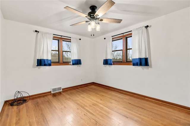 empty room with hardwood / wood-style floors and ceiling fan