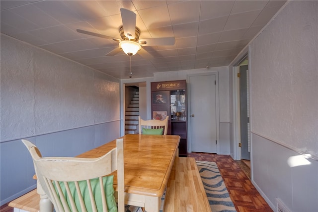 dining space with parquet flooring and ceiling fan