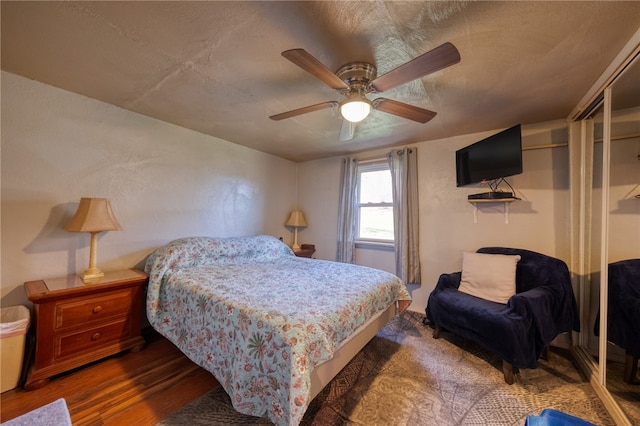 bedroom featuring ceiling fan, dark hardwood / wood-style flooring, and a closet