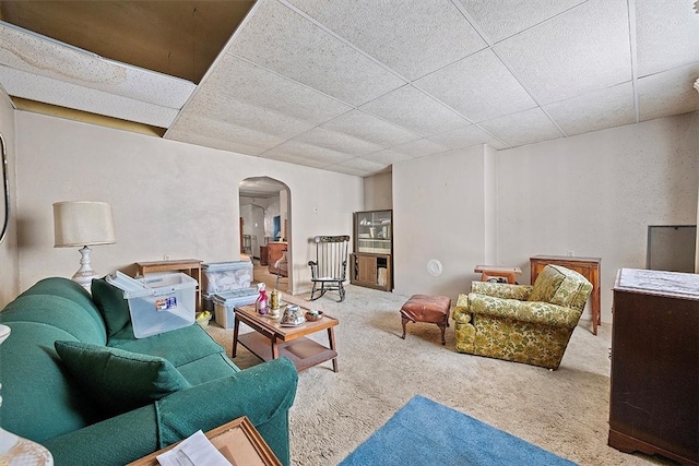 carpeted living room with a drop ceiling