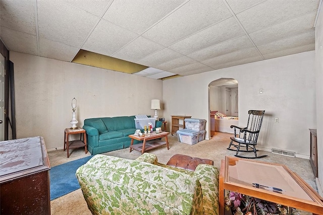 living room with carpet flooring and a paneled ceiling