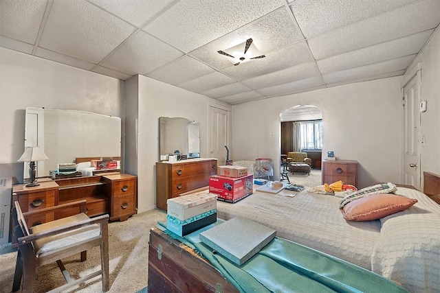 interior space with a paneled ceiling and light colored carpet