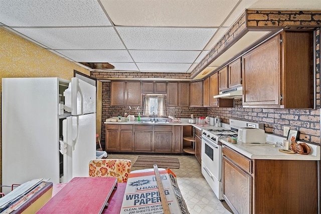 kitchen featuring a paneled ceiling, sink, and white stove