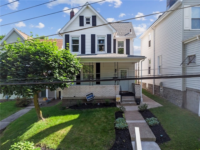 view of front facade featuring a front yard and covered porch