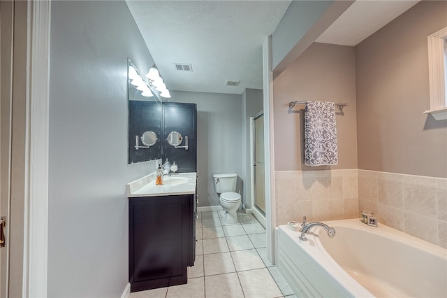 bathroom with vanity, tile patterned floors, toilet, a tub to relax in, and a textured ceiling