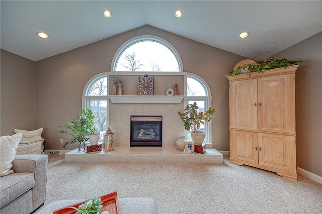 unfurnished living room featuring a tiled fireplace, carpet, and lofted ceiling