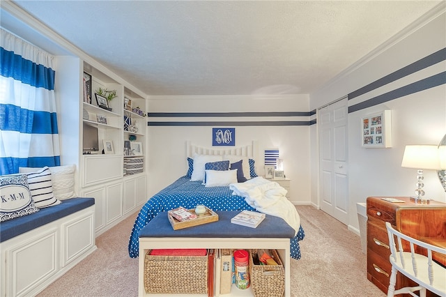 bedroom featuring light carpet, a closet, a textured ceiling, and ornamental molding