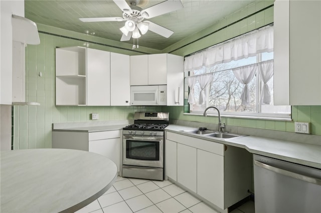 kitchen featuring light tile patterned flooring, stainless steel appliances, white cabinetry, and sink