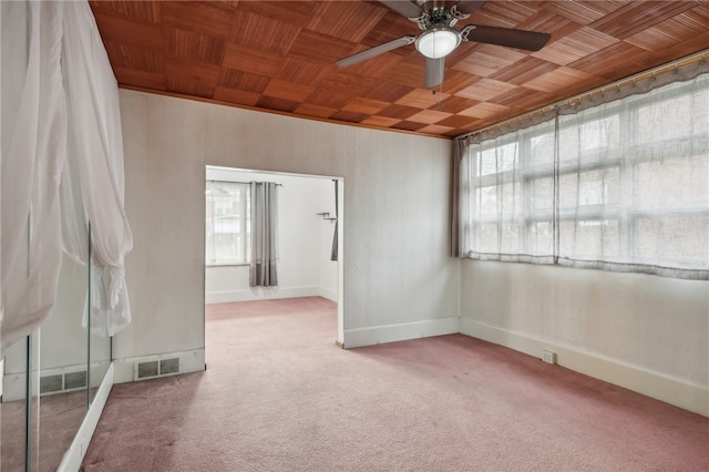 carpeted empty room featuring a wealth of natural light, wooden ceiling, and ceiling fan