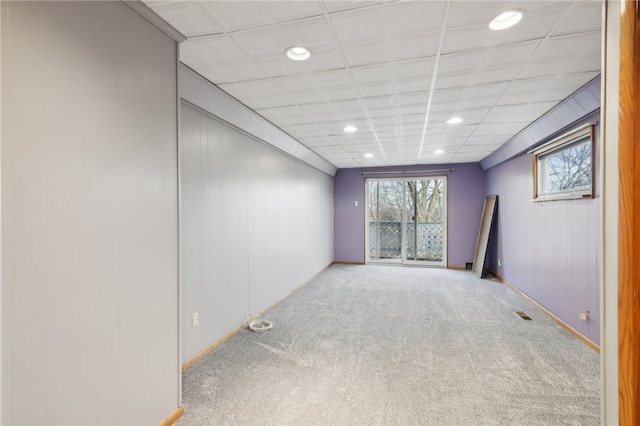 carpeted spare room with a paneled ceiling