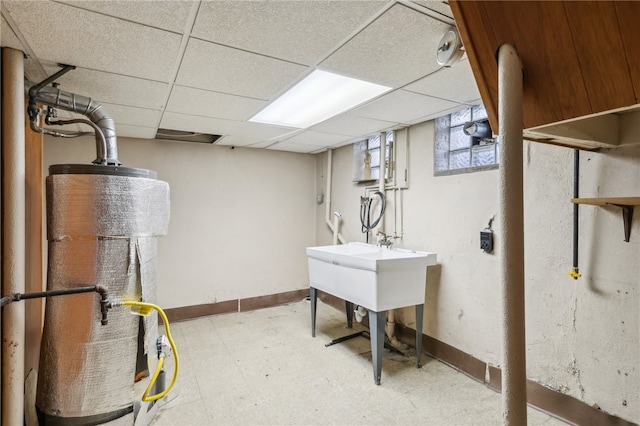 basement featuring a drop ceiling and water heater