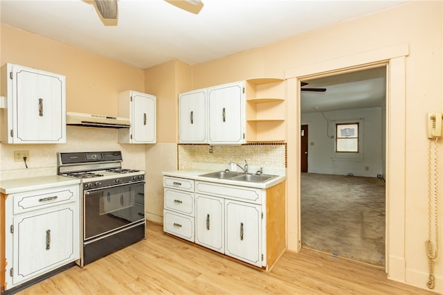 kitchen featuring black range with gas stovetop, ceiling fan, sink, exhaust hood, and white cabinetry