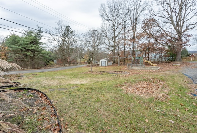 view of yard with a storage unit and a playground