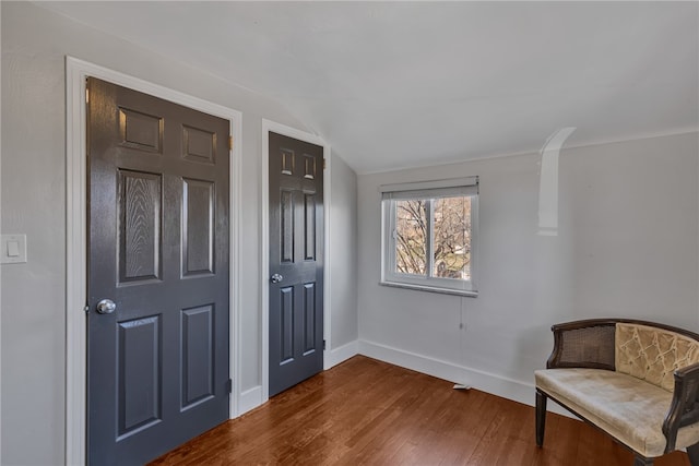 unfurnished room featuring vaulted ceiling and dark hardwood / wood-style floors