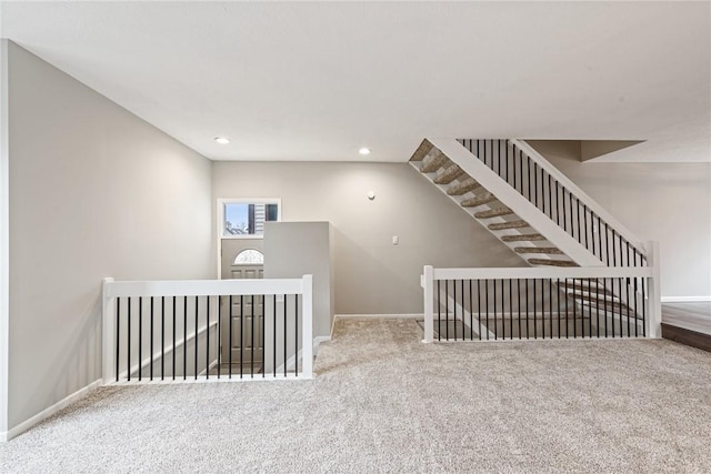 staircase featuring carpet