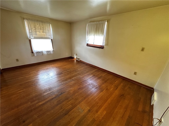 spare room with dark wood-type flooring