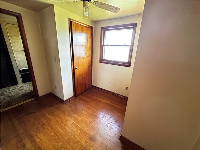 unfurnished bedroom with a closet, hardwood / wood-style flooring, and ceiling fan