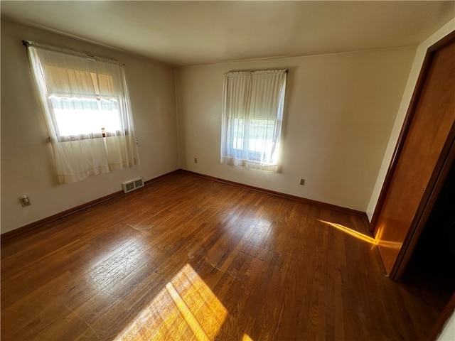 unfurnished room featuring hardwood / wood-style floors and a healthy amount of sunlight