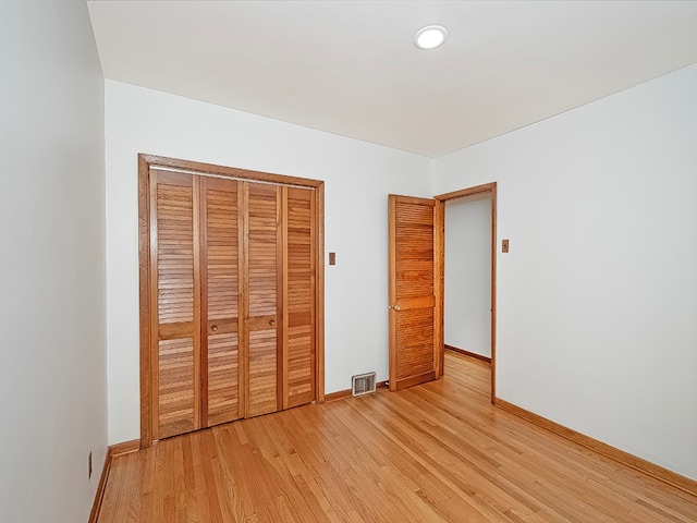 unfurnished bedroom featuring light hardwood / wood-style flooring and a closet