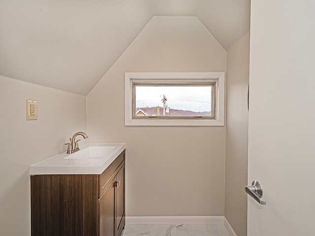 bathroom featuring vanity and lofted ceiling