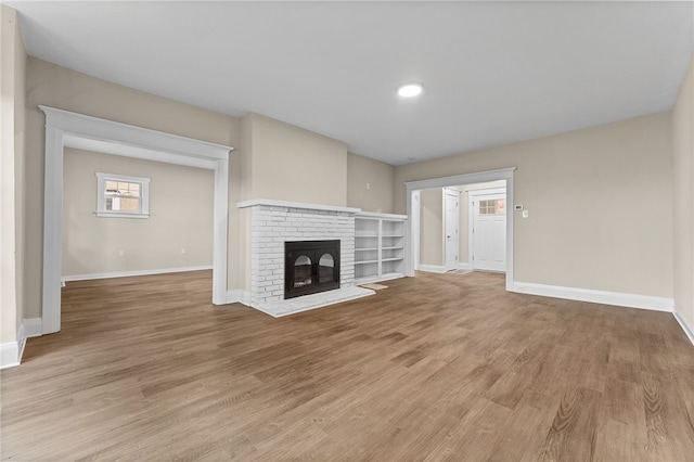 unfurnished living room with a fireplace and light hardwood / wood-style floors