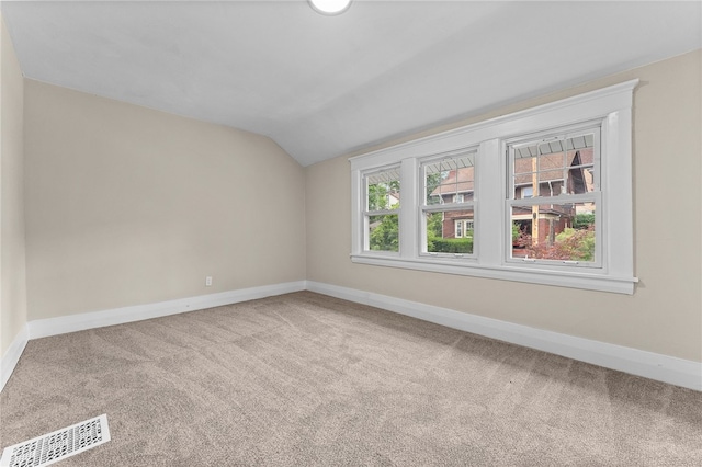 spare room featuring lofted ceiling and carpet floors