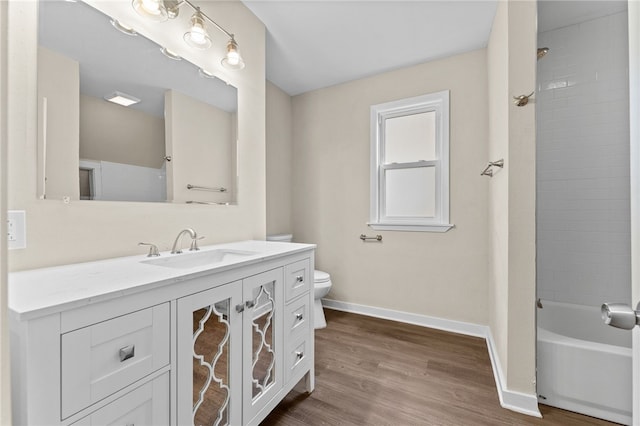 full bathroom with tiled shower / bath, toilet, vanity, and hardwood / wood-style flooring