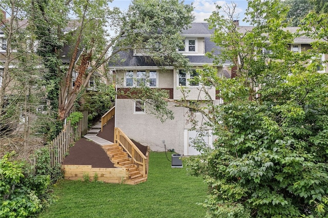 back of property with central AC unit and a lawn