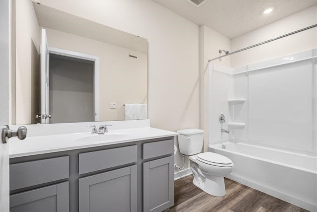 full bathroom with shower / bath combination, vanity, hardwood / wood-style flooring, and toilet