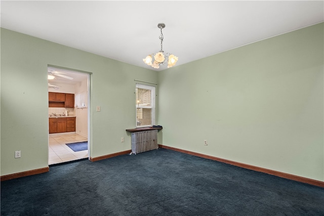 carpeted spare room with a notable chandelier, radiator heating unit, and sink